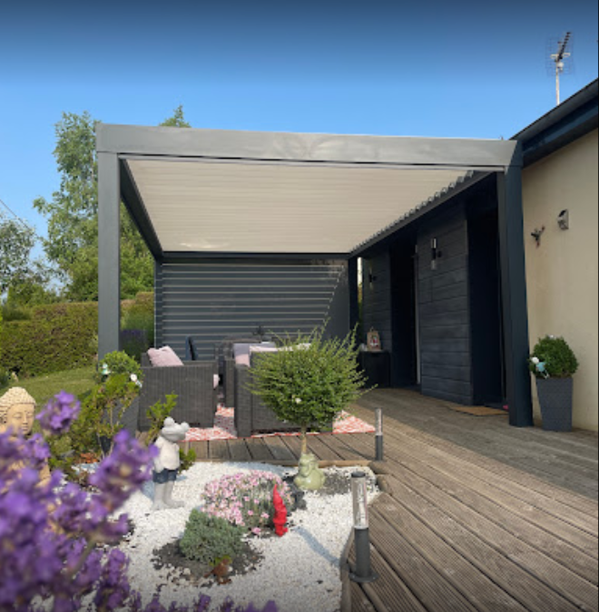 pergola bioclimatique concept alu aux lames orientables sur une belle terrasse de maison en Normandie