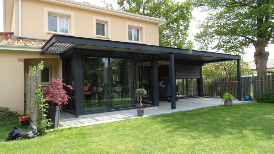 extension de maison avec un toit plat en normandie doublée d'une pergola bioclimatique. Gamme extenxia